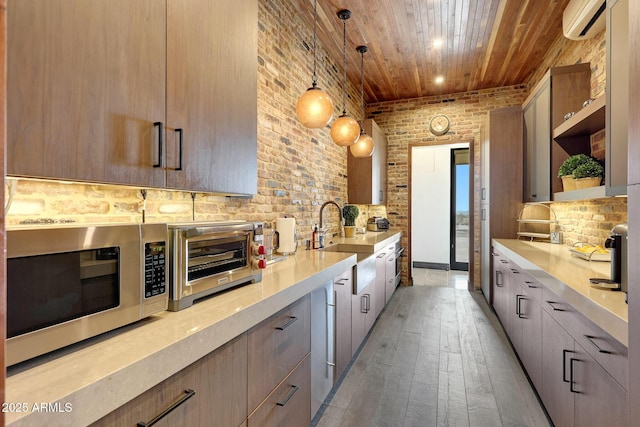 kitchen with wood ceiling, hanging light fixtures, light brown cabinetry, and light hardwood / wood-style flooring