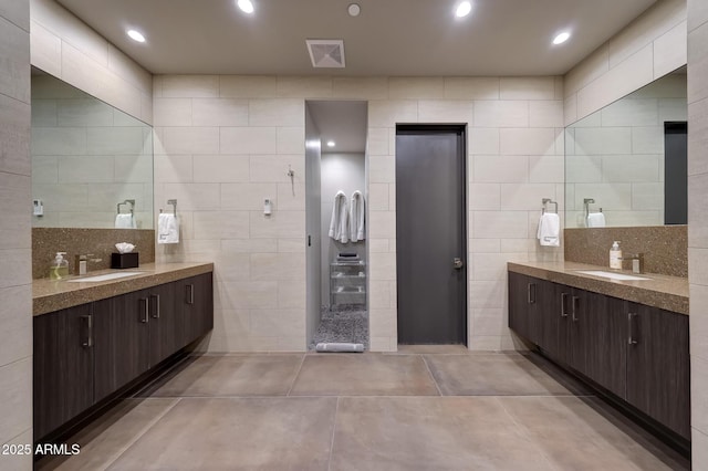 bathroom with vanity and tile walls