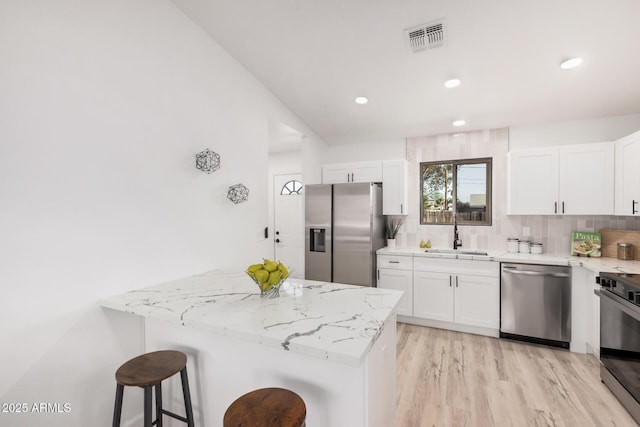 11025 E Cholla Rd, Mesa, AZ 85207 - kitchen featuring stainless steel appliances, a sink, light stone counters, a kitchen bar, and recessed lighting