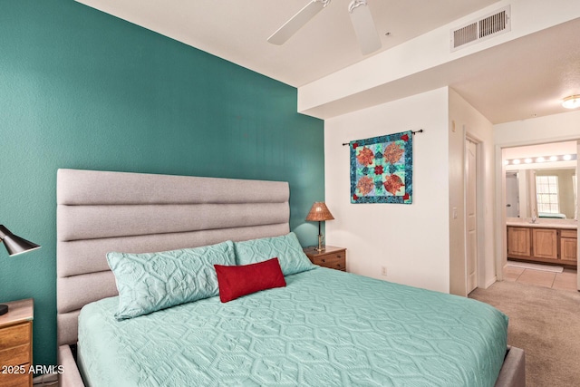 carpeted bedroom featuring visible vents, a ceiling fan, and connected bathroom