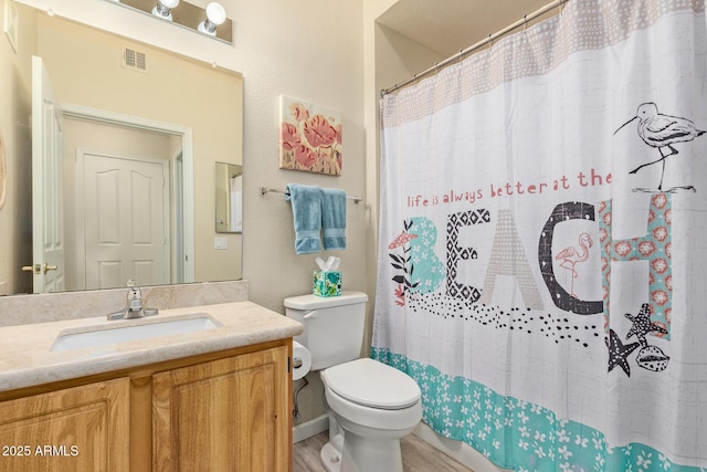 bathroom featuring visible vents, vanity, wood finished floors, toilet, and a shower with shower curtain