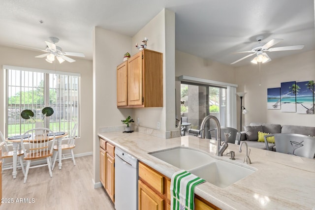 kitchen with a sink, light wood finished floors, dishwasher, a ceiling fan, and open floor plan