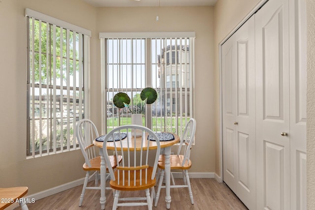 dining space with baseboards and wood finished floors
