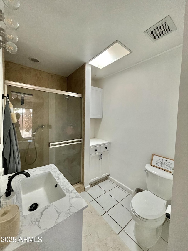 bathroom featuring vanity, toilet, a shower with shower door, and tile patterned flooring