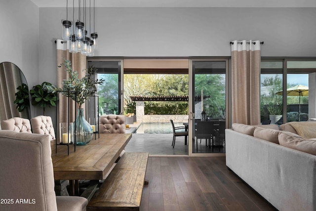 dining area with dark wood-type flooring and an inviting chandelier