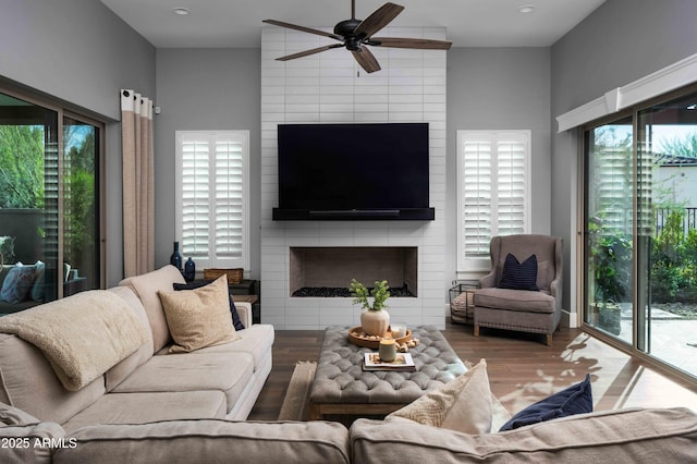 living room with ceiling fan, a healthy amount of sunlight, a fireplace, and hardwood / wood-style floors