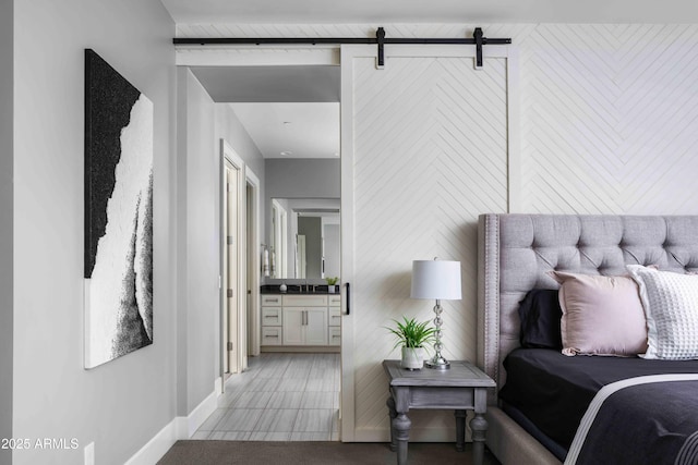 bedroom featuring sink, a barn door, and ensuite bath