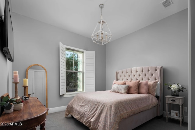 bedroom featuring dark colored carpet and a notable chandelier