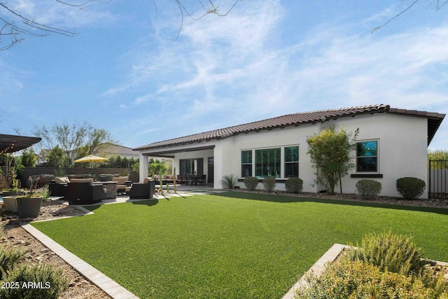 rear view of house with outdoor lounge area, a yard, and a patio