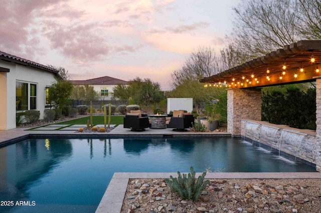 pool at dusk with an outdoor hangout area, pool water feature, a patio area, and a pergola