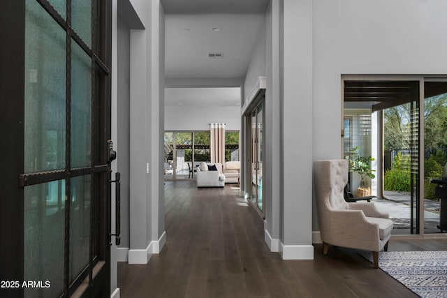 hall with a high ceiling, dark hardwood / wood-style flooring, and french doors