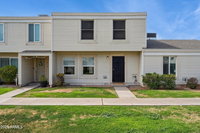 townhome / multi-family property featuring a front lawn