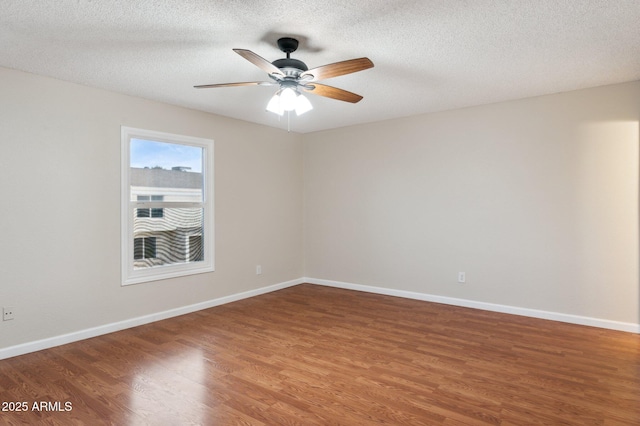 empty room featuring ceiling fan, a textured ceiling, wood finished floors, and baseboards