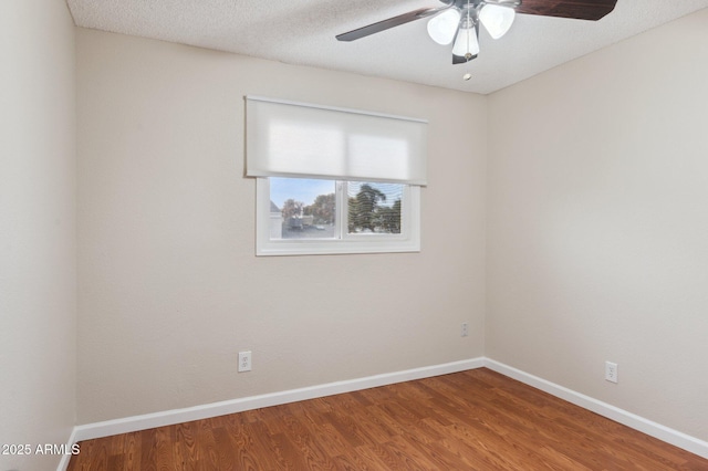 spare room with ceiling fan, a textured ceiling, baseboards, and wood finished floors