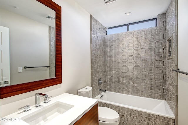 full bathroom with vanity, tiled shower / bath combo, and toilet