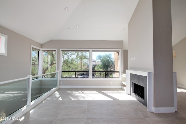 unfurnished living room featuring high vaulted ceiling and light tile patterned flooring