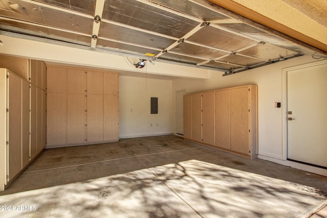 garage with a garage door opener and electric panel