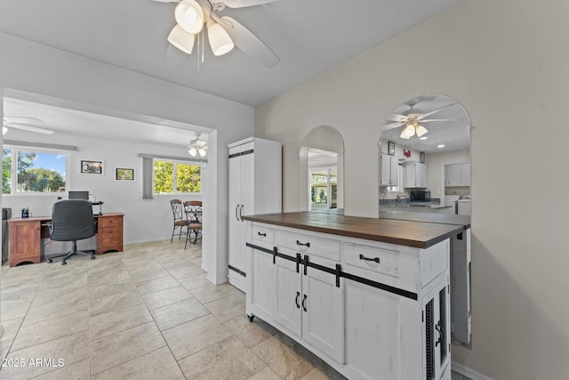 kitchen featuring white cabinetry, wood counters, separate washer and dryer, and ceiling fan