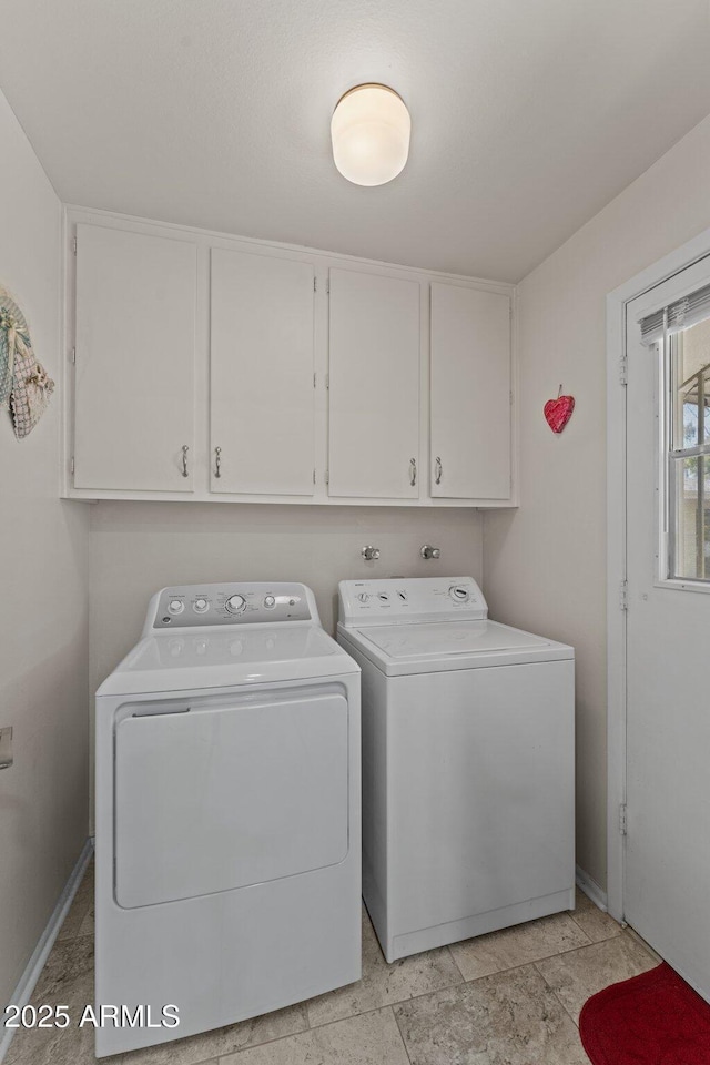 laundry area featuring washer and clothes dryer and cabinets