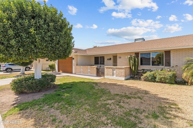 ranch-style house featuring a garage and a front yard