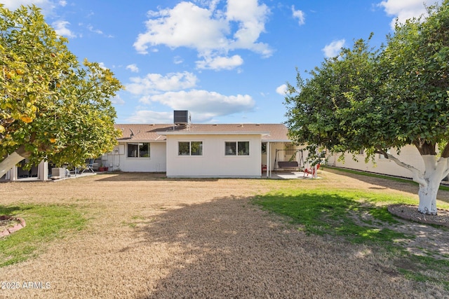 back of house featuring a yard, central AC, and a patio