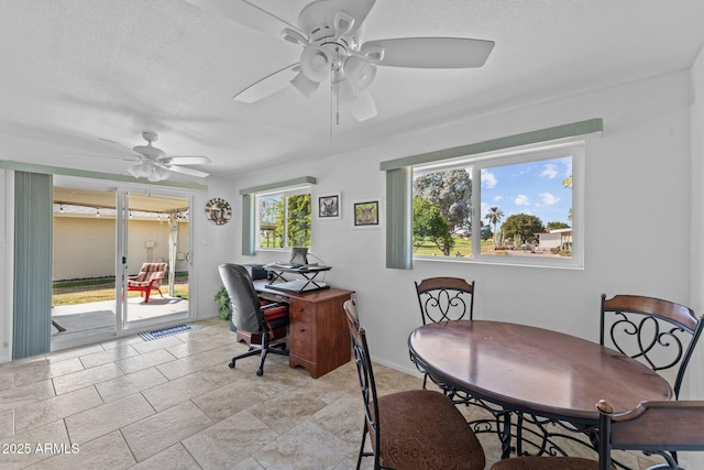 dining space with a textured ceiling and ceiling fan