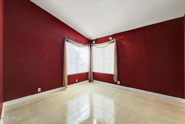 tiled empty room with vaulted ceiling