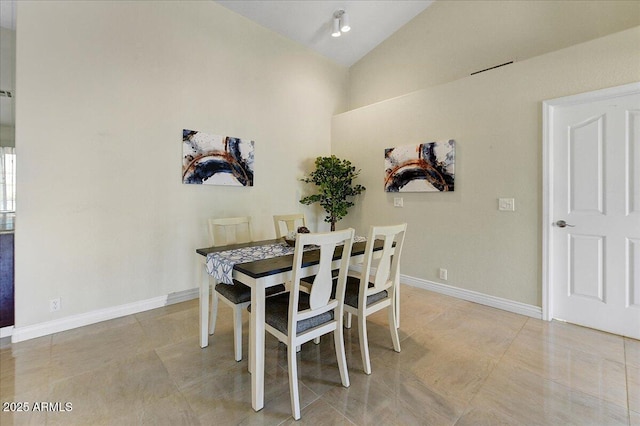 dining area with light tile patterned floors and lofted ceiling