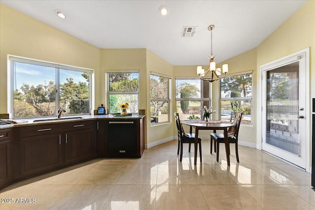 interior space with pendant lighting, dark brown cabinetry, sink, a notable chandelier, and light tile patterned floors