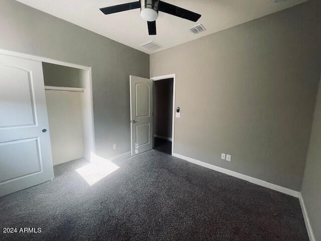 unfurnished bedroom featuring ceiling fan, a closet, and carpet flooring