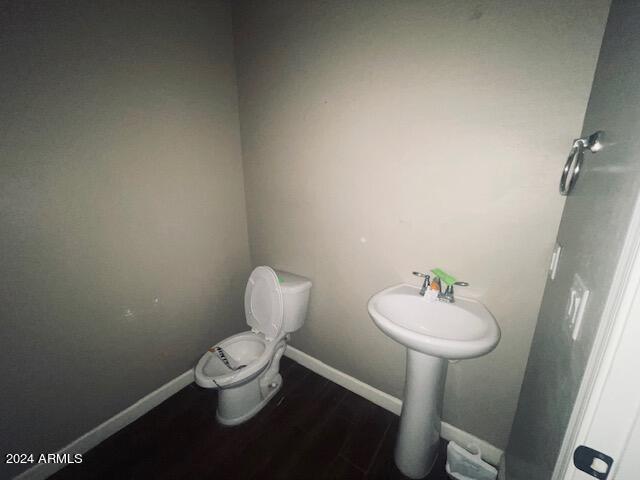 bathroom featuring wood-type flooring and toilet