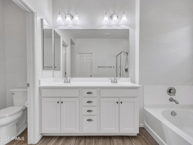 full bathroom with a bath, a sink, toilet, and double vanity