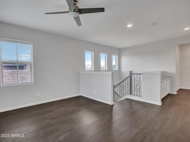 empty room with recessed lighting, dark wood-style flooring, and baseboards