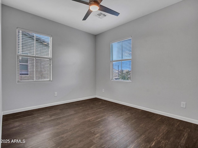 spare room with visible vents, ceiling fan, baseboards, and wood finished floors