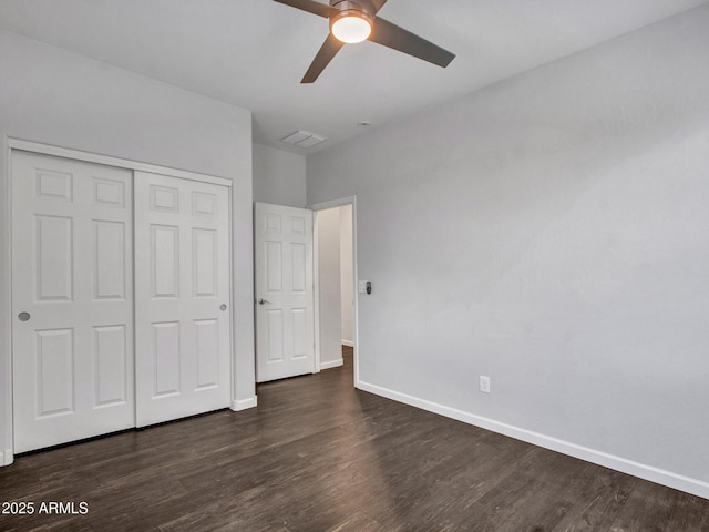 unfurnished bedroom with ceiling fan, wood finished floors, visible vents, baseboards, and a closet