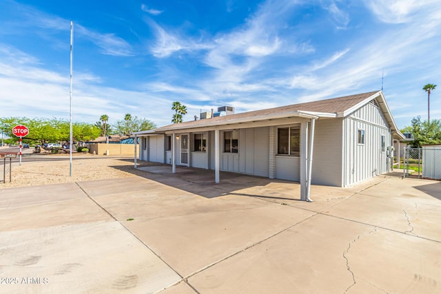 4343 E Union Hills Dr, Phoenix, AZ 85050 - view of front facade with board and batten siding, fence, and concrete driveway