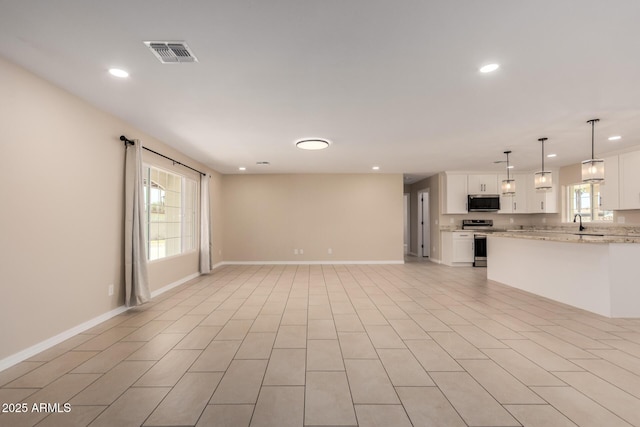 8124 N 45th Ave, Glendale, AZ 85302 - unfurnished living room with baseboards, recessed lighting, plenty of natural light, and a sink