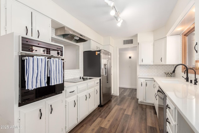 kitchen with a sink, stainless steel appliances, visible vents, and white cabinetry