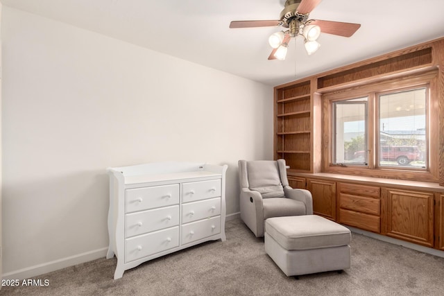 living area with light carpet, a ceiling fan, and baseboards