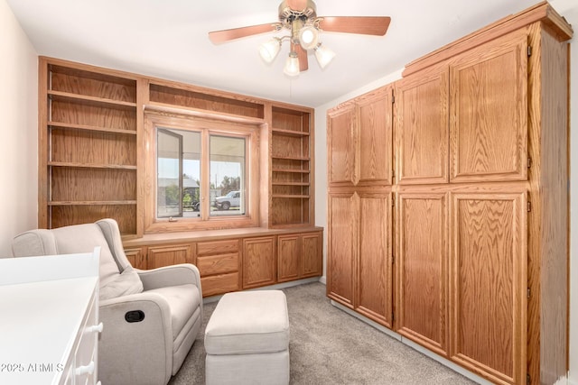 sitting room featuring light colored carpet and ceiling fan