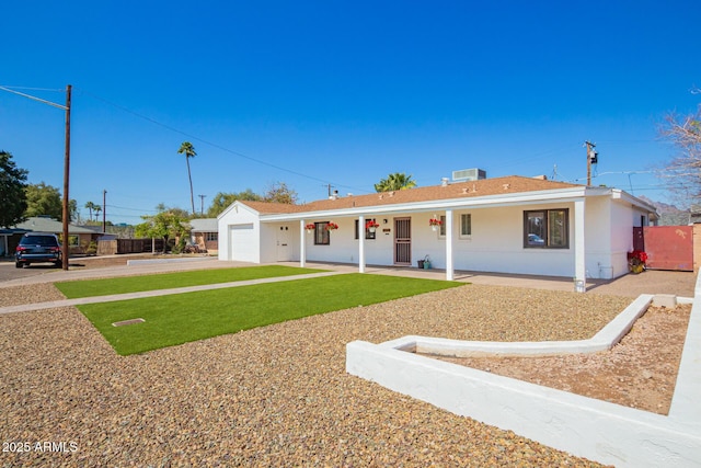 ranch-style house featuring a porch, an attached garage, stucco siding, concrete driveway, and a front lawn