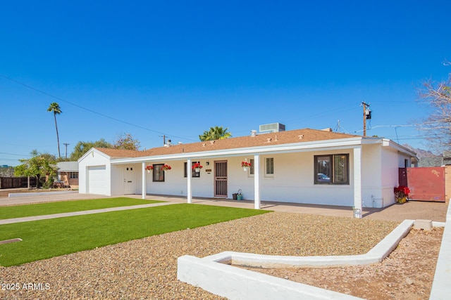 ranch-style home with a front lawn, fence, stucco siding, driveway, and an attached garage