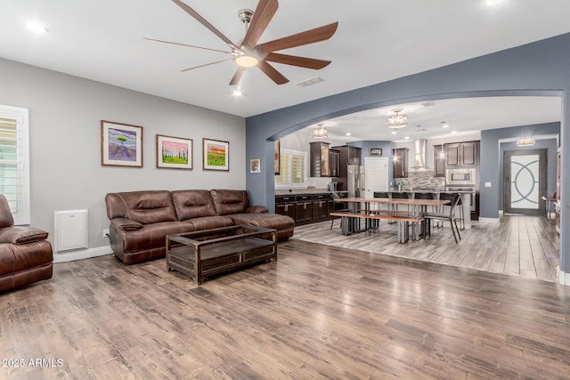 10738 W Rowel Rd, Peoria, AZ 85383 - living area with a ceiling fan, light wood finished floors, arched walkways, recessed lighting, and a chandelier
