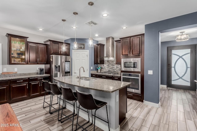 10738 W Rowel Rd, Peoria, AZ 85383 - kitchen featuring stainless steel appliances, a sink, wall chimney exhaust hood, a breakfast bar, and wood tiled floors