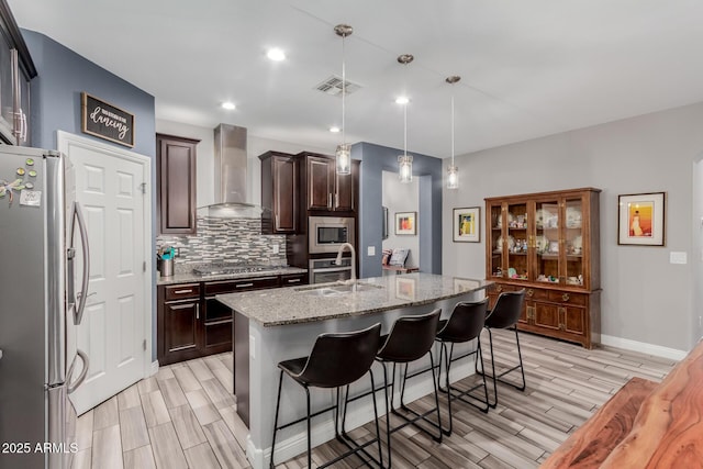 10738 W Rowel Rd, Peoria, AZ 85383 - kitchen featuring appliances with stainless steel finishes, wall chimney exhaust hood, a sink, wood tiled floors, and tasteful backsplash