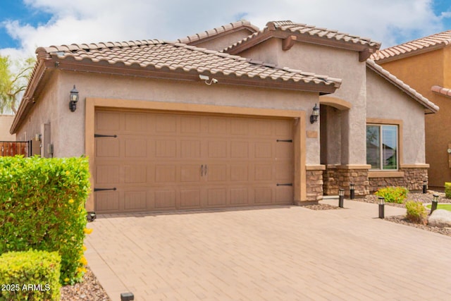 10738 W Rowel Rd, Peoria, AZ 85383 - mediterranean / spanish home featuring a garage, decorative driveway, stone siding, and stucco siding