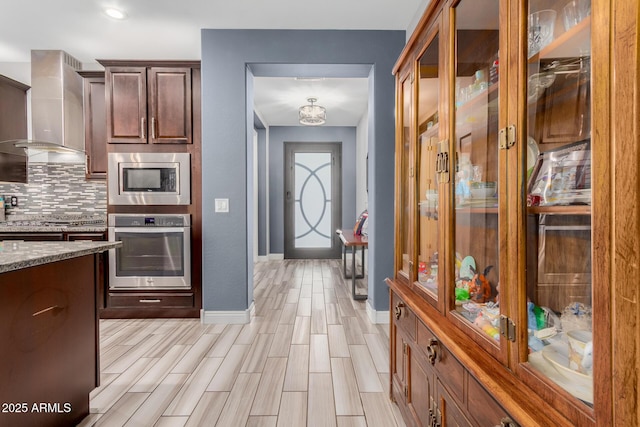 10738 W Rowel Rd, Peoria, AZ 85383 - kitchen with stainless steel appliances, wall chimney range hood, decorative backsplash, light stone countertops, and baseboards