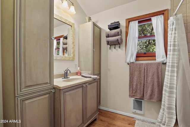 bathroom with vanity, wood-type flooring, and vaulted ceiling