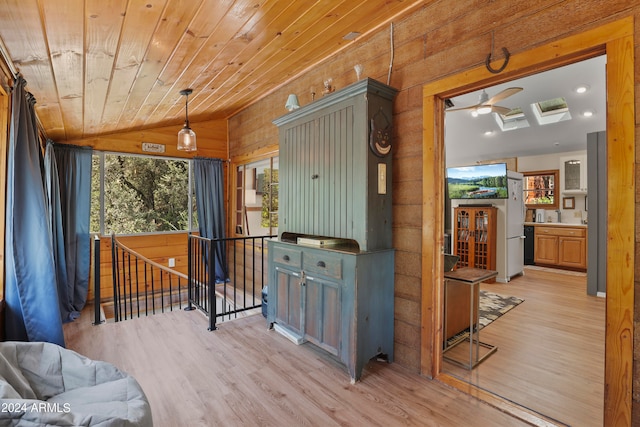 hall with light wood-type flooring, lofted ceiling with skylight, and wooden ceiling