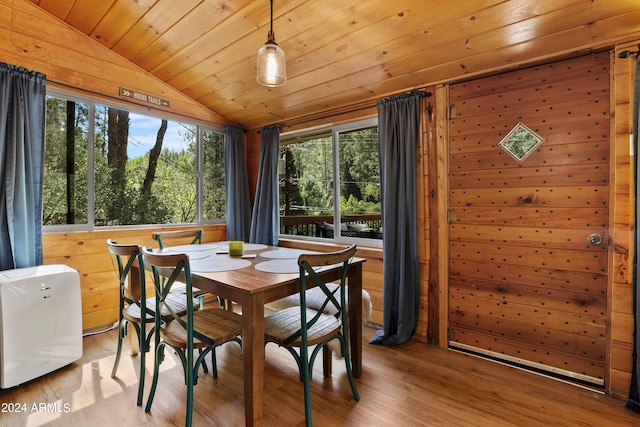 dining area with wood ceiling, wood walls, and light hardwood / wood-style floors